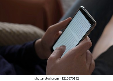 Man Scrolling And Reading Messages On His Smartphone