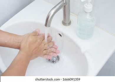 A Man Scrubbing His Hands With Soap In A Basin To Keep Them Clean And Kill Bacteria Or Germs. Prevention Against Flu Or Corona. (motion Blur Hands)