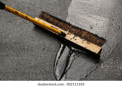 Man Sealing Asphalt Driveway