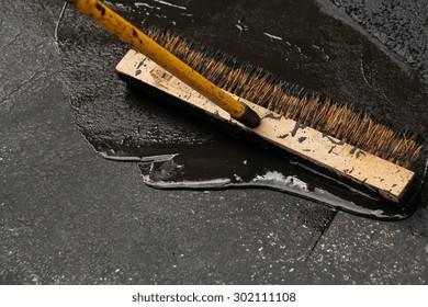 Man Sealing Asphalt Driveway