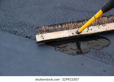 Man Sealing Asphalt Driveway