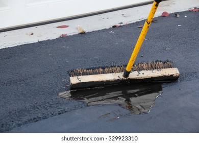 Man Sealing Asphalt Driveway