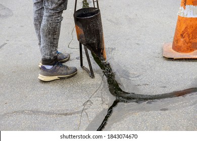 Man Sealing Asphalt Driveway With Filled Cracks Sealcoating Selective Focus