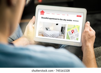 Man search apartments and houses online with mobile device. Holiday home rental or real estate website or application. Imaginary internet marketplace for vacation lodging or finding new home. - Shutterstock ID 745161328