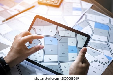 A Man Searching Building Plot On A Cadastral Plan To Choose And Buy A Building Plot For House Construction On A Digital Tablet