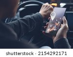 Man searching destination direction or address on GPS or navigator application via mobile smartphone inside a car in the city at night while driving car