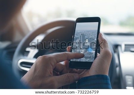 Man searching destination direction or address on gps or navigator application via  mobile smartphone inside a car while driving car, close up