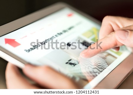 Man searching holiday home, vacation apartment or property for rent online with tablet. Person thinking of buying new house on internet. Finding rental flat. Real estate website. Investment research.
