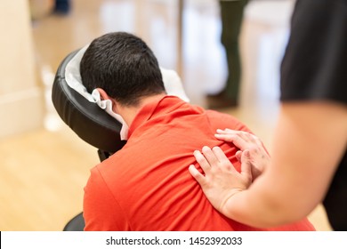Man seated in a massage chair for back massage.