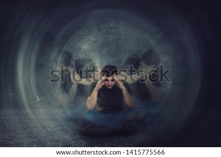 Man seated on the floor, hands to head, suffer split emotions into different inner personalities. Multipolar mental health disorder. Schizophrenia psychiatric disease. Dementia reactions mood change.