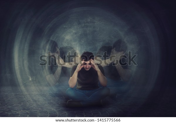 Man seated on the floor, hands to head, suffer\
split emotions into different inner personalities. Multipolar\
mental health disorder. Schizophrenia psychiatric disease. Dementia\
reactions mood change.