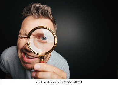 man see through magnifying glass on the black backgrounds. Big man eye