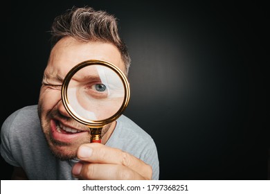 Man See Through Magnifying Glass On The Black Backgrounds. Big Man Eye