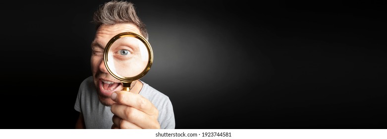 Man See Through Magnifying Glass On The Black Backgrounds. Big Man Eye