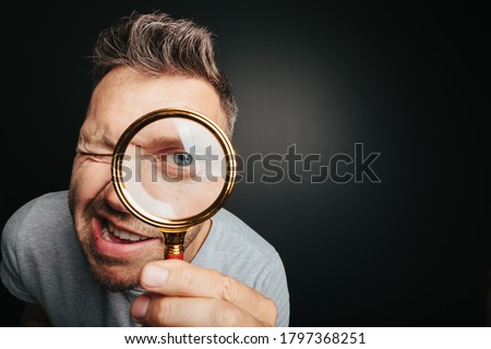 man see through magnifying glass on the black backgrounds. Big man eye Сток-фото © 