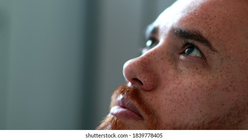 Man seeking help from God looking up, redhead guy closing eyes in contemplation and spirituality
