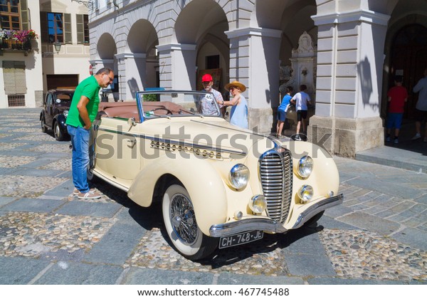 The man sees the car\
on exhibition of old cars 1910-1940 years. in the town of Ceva,\
Italy. August 5, 2016
