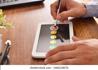 Man selecting an unsatisfactory response on a device in an office