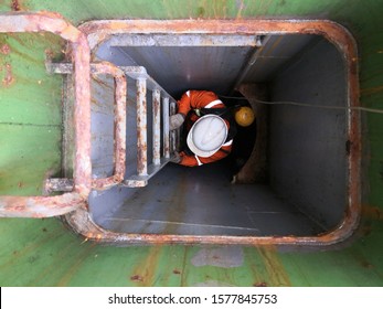 A Man With Self Contained Breathing Apparatus And Lifeline Is Climbing On The Ladder Into An Enclosed Space On Cargo Ship For Training And Drill During PSC CIC 2019 -  Concentrate Inspection Campaigns