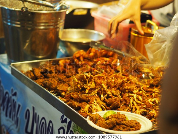 Man selling fried\
edible insects at a night market (Bangkok, Thailand) (Translation:\
Fried insects for sale)