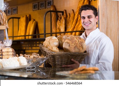 Man selling  pastry and baguettes in local bakery - Powered by Shutterstock