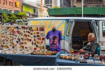 Man Sells Jewelry And Souvenirs At Tables On Manhattan Sidewalk.