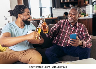 Man with senior father watch football together with beer celebrating