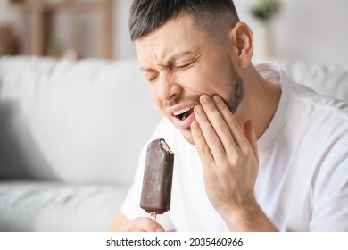 Man with sensitive teeth and ice-cream at home