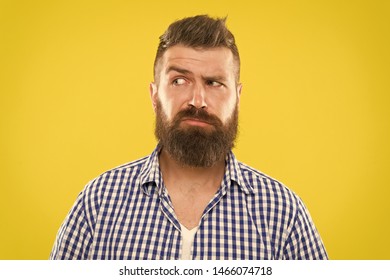Man serious face raising eyebrow not confident. Have some doubts. Hipster bearded face not sure in something. Doubtful bearded man on yellow background close up. Doubtful expression. Need to think.
