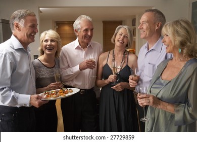 Man Serving Hors D'oeuvres To His Guests At A Dinner Party