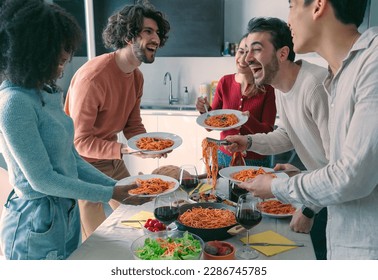 man serving pasta to his friends during lunch in dining room.