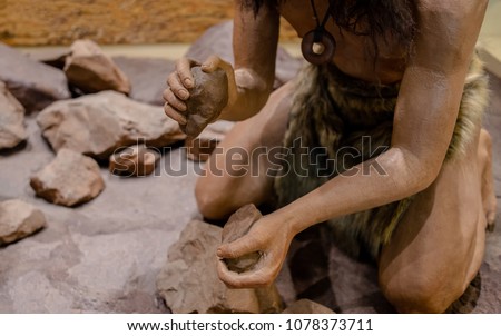 man set on fire with fire stone for cooking in stone age