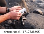 man sets up an action camera using a phone, leisure theme and backgrounds
