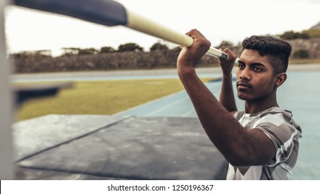 Man Setting Up A Pole At A Height For High Jump. Close Up Of A Man Resetting The Height Of The Bar For High Jump.