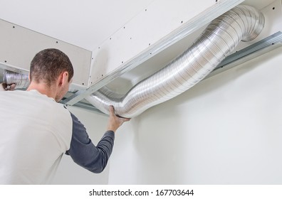 Man setting up ventilation system indoors