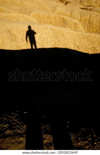 Man shadow
silhouette projected over a dried mud ravine yellowed by the
setting sun at Berca Mud Volcanoes
reservation