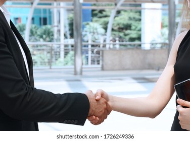 Man shaking hands with client women after talking business 
