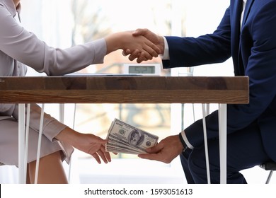 Man Shaking Woman's Hand And Giving Bribe Money Under Table, Closeup