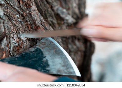 Man Sharpening Axe Blade