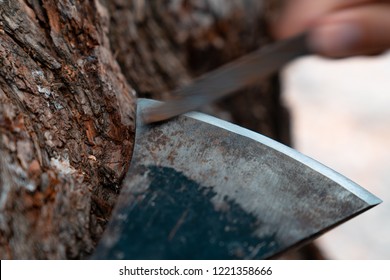 Man Sharpening Axe Blade