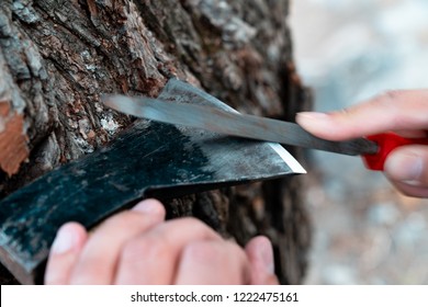 Man Sharpening Axe Blade