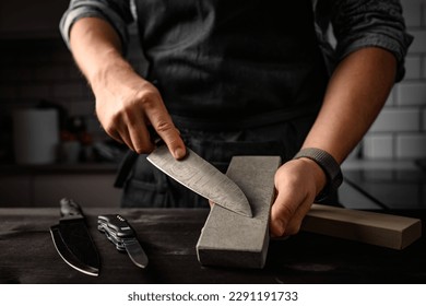 Man sharpening a knife with sharpen stone tool. Master sharpening knife on a grindstone - Powered by Shutterstock