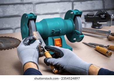 Man Sharpening Work Tool, Chisel On Grinder In Workshop. - Powered by Shutterstock