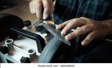 Man sharpens knives on a grinder. Close up hand - Powered by Shutterstock