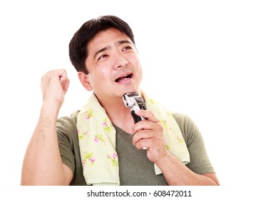 A Man Shaving With Electric Razor