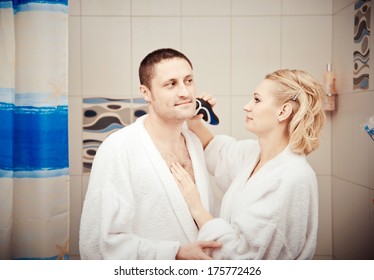 Man Shaving Electrorazor. Woman Shaves Man