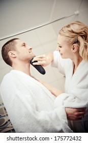 Man Shaving Electrorazor. Woman Shaves Man