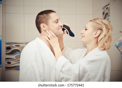 Man Shaving Electrorazor. Woman Shaves Man