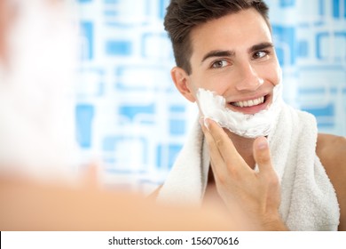 Man Shaving His Face Getting Ready For The Day