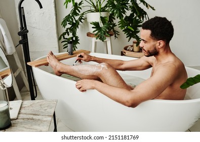 Man shaving his legs in bath - Shutterstock ID 2151181769
